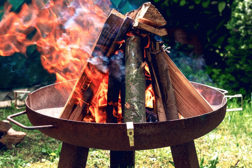 Feuerschale im Garten mit brennendem Holz