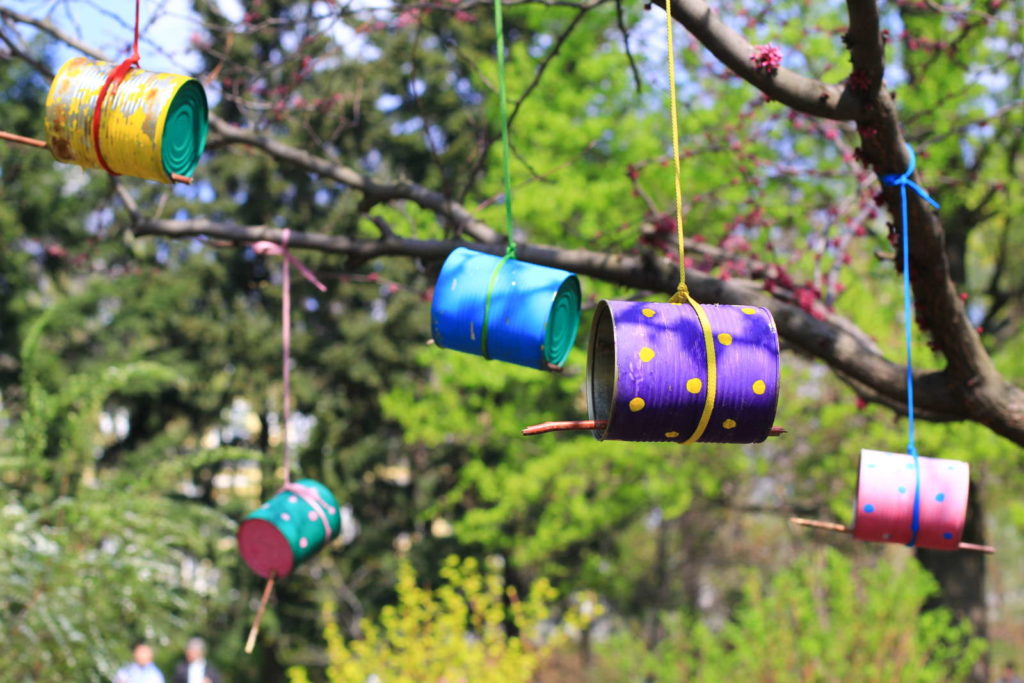 Vogelhäuser aus Dosen hängen an einem Baum im Garten