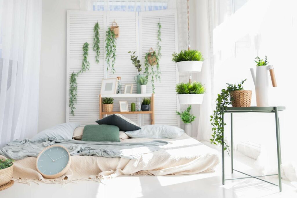 Weißes Schlafzimmer mit vielen Pflanzen und Uhr