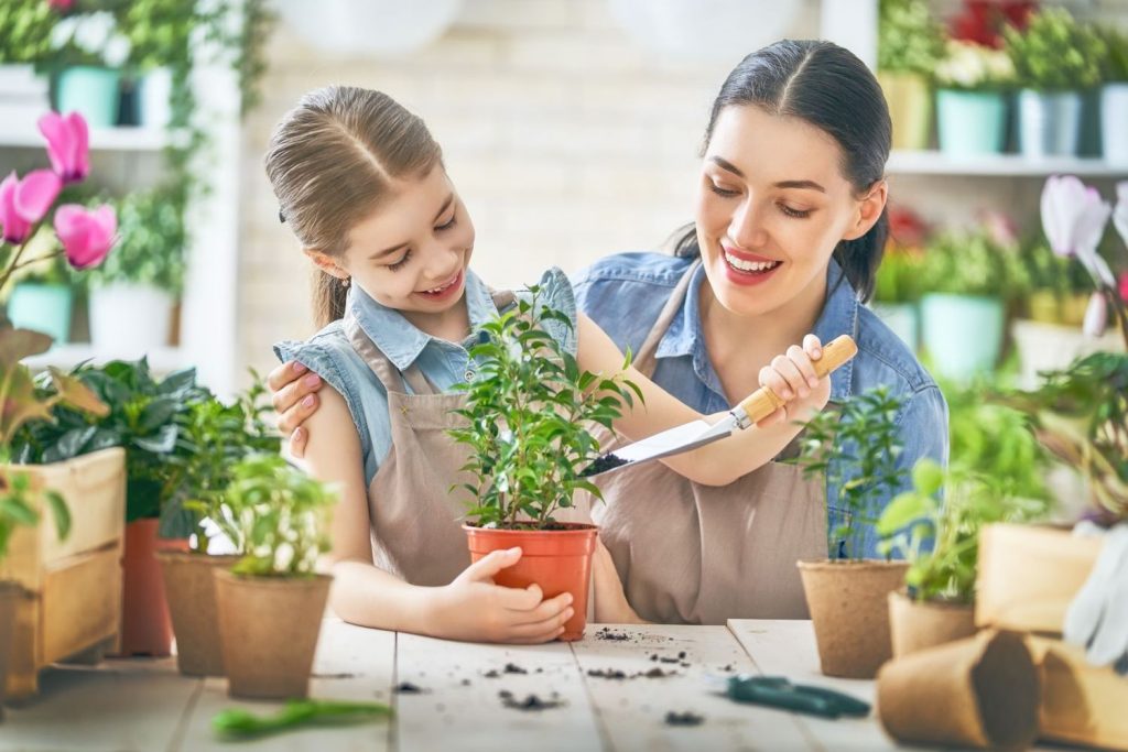 Mutter und Tochter gärtnern im Haus