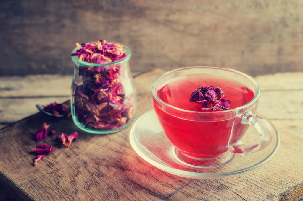Tee aus Rosenblüten in Glastasse