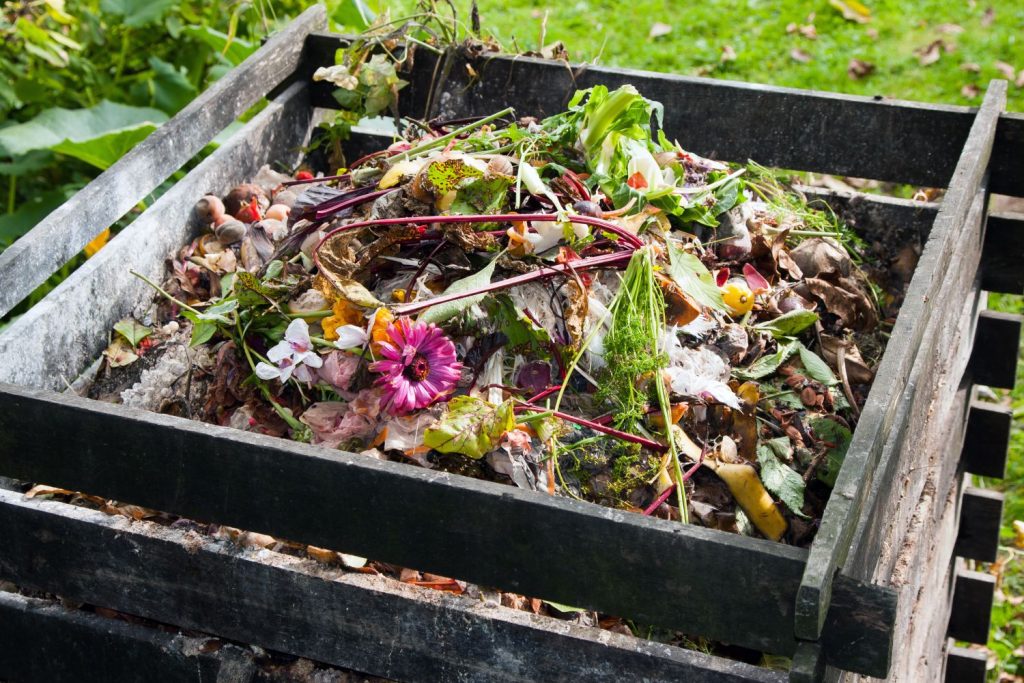 Komposthaufen in einem Holzrahmen im Garten