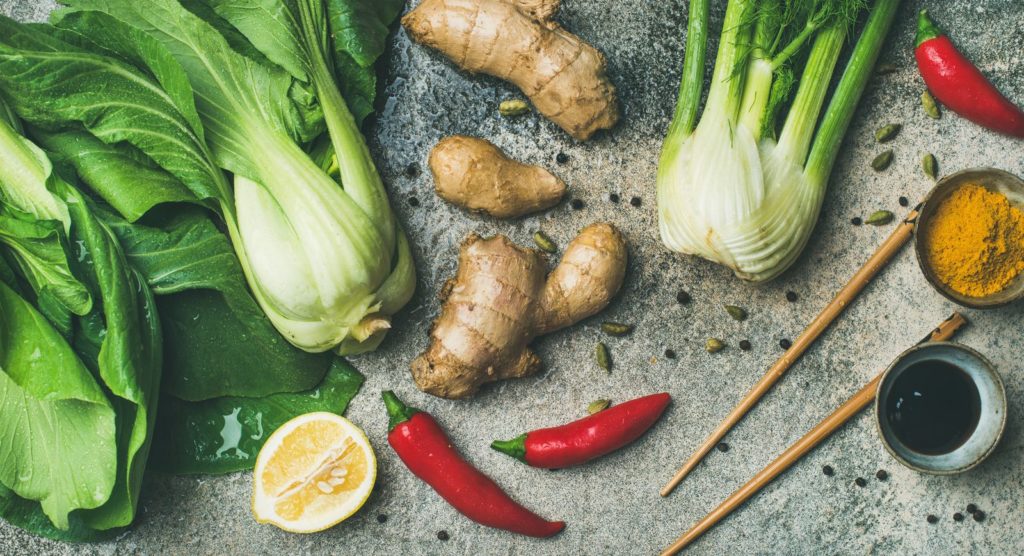 Asiatisches Gemüse, wie z.B. Ingwer, mit Gewürzen und Stächen auf Tisch
