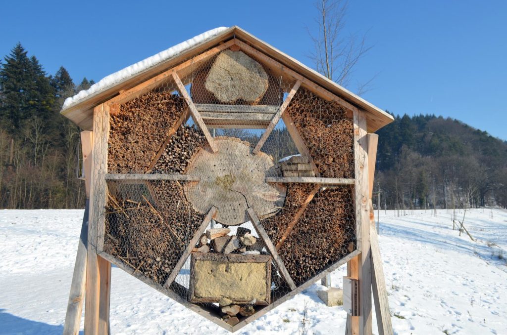 Insektenhotel auf verschneiter Wiese