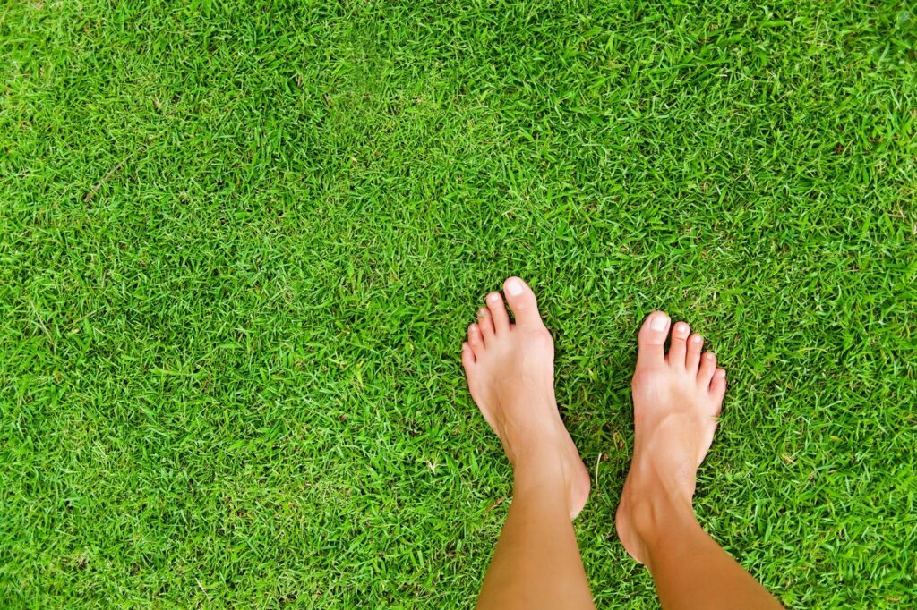 Nackte Füße auf Rasen