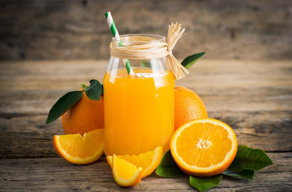 Orangen aufgeschnitten und Saft auf Tisch