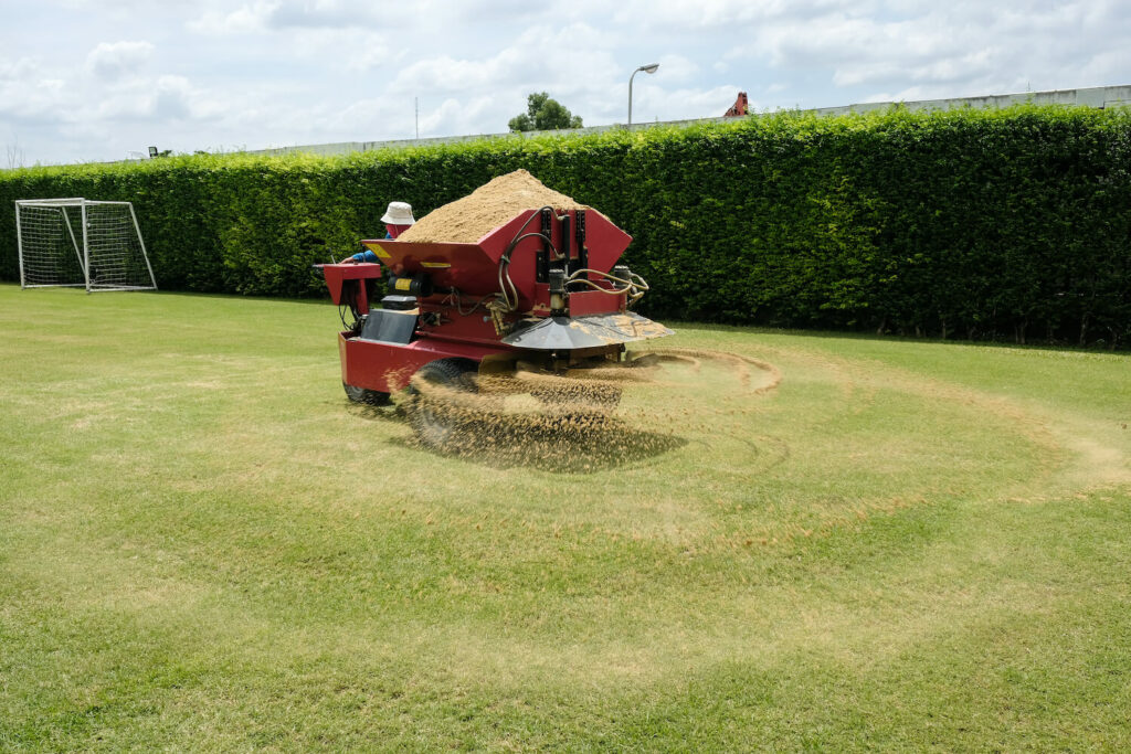 Rasen-Sanden mit Streuwagen